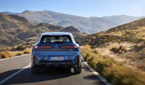 Rear action shot of a 2026 BMW iX3