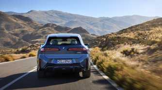 Rear action shot of a 2026 BMW iX3