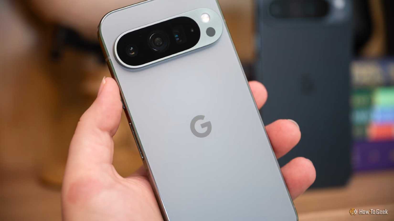 Person holding the Google Pixel 9 Pro in front of the 9 Pro XL-1.