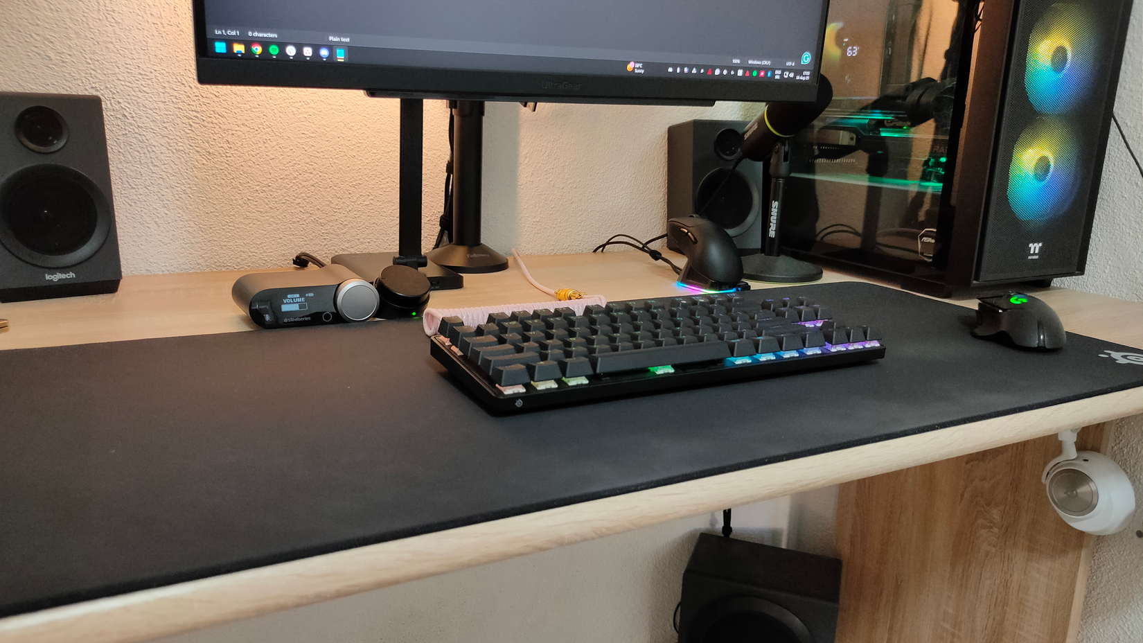 A gaming PC computer desk with a slightly dirty mousepad.