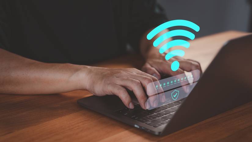 Person logs into a laptop computer using a Wi-Fi connection.