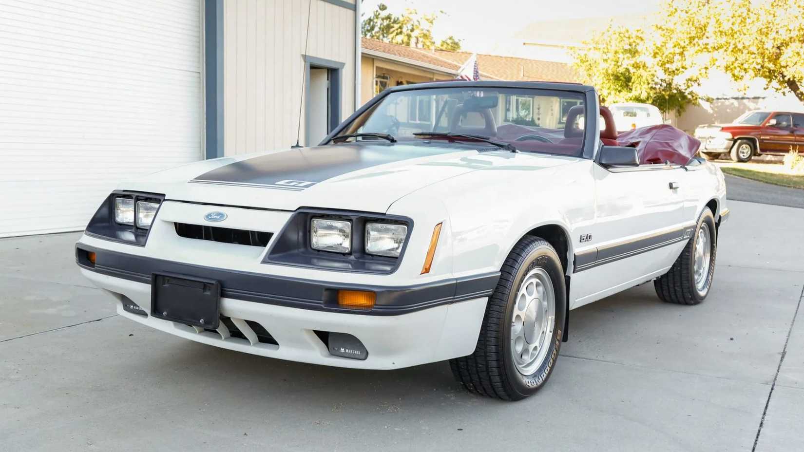 Plan statique 3/4 avant d'une Ford Mustang décapotable blanche de 1986.