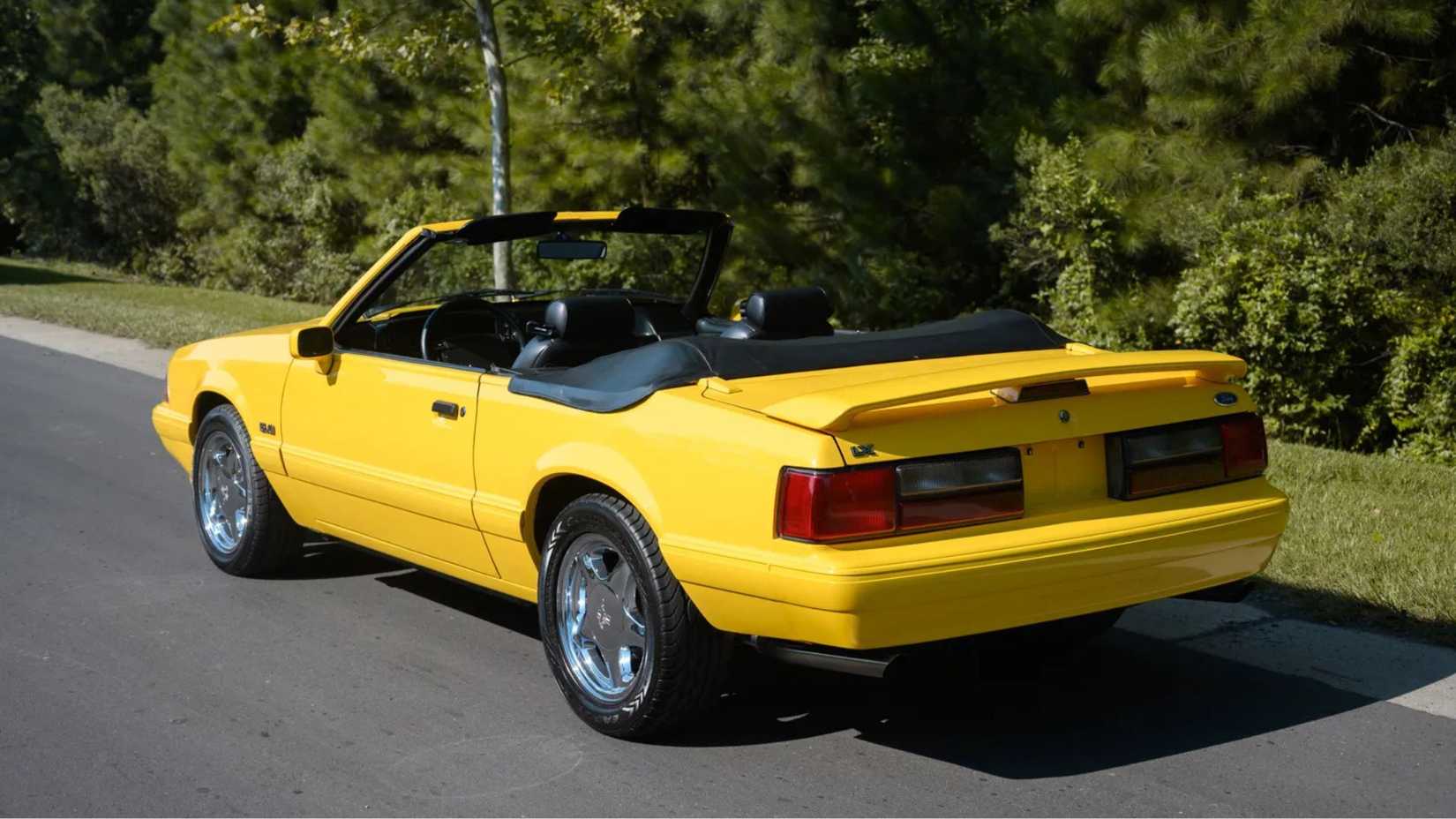 Plan 3/4 arrière statique d'une Ford Mustang LX 5.0 cabriolet jaune 1993 à 5 vitesses.