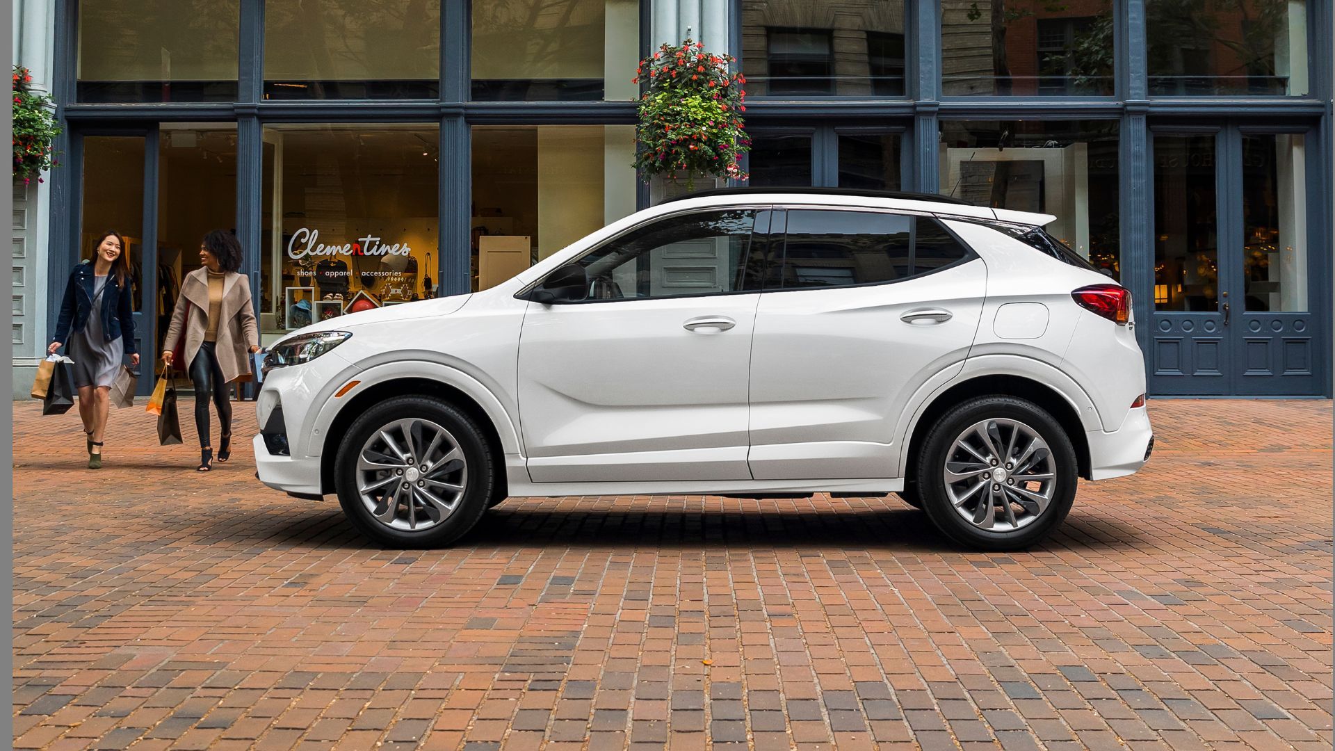 都市に駐車されている白い 2021 年型ビュイック アンコール GX の静的な横顔ショット。