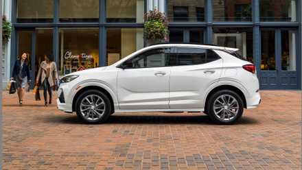Static side profile shot of a white 2021 Buick Encore GX parked in a city.