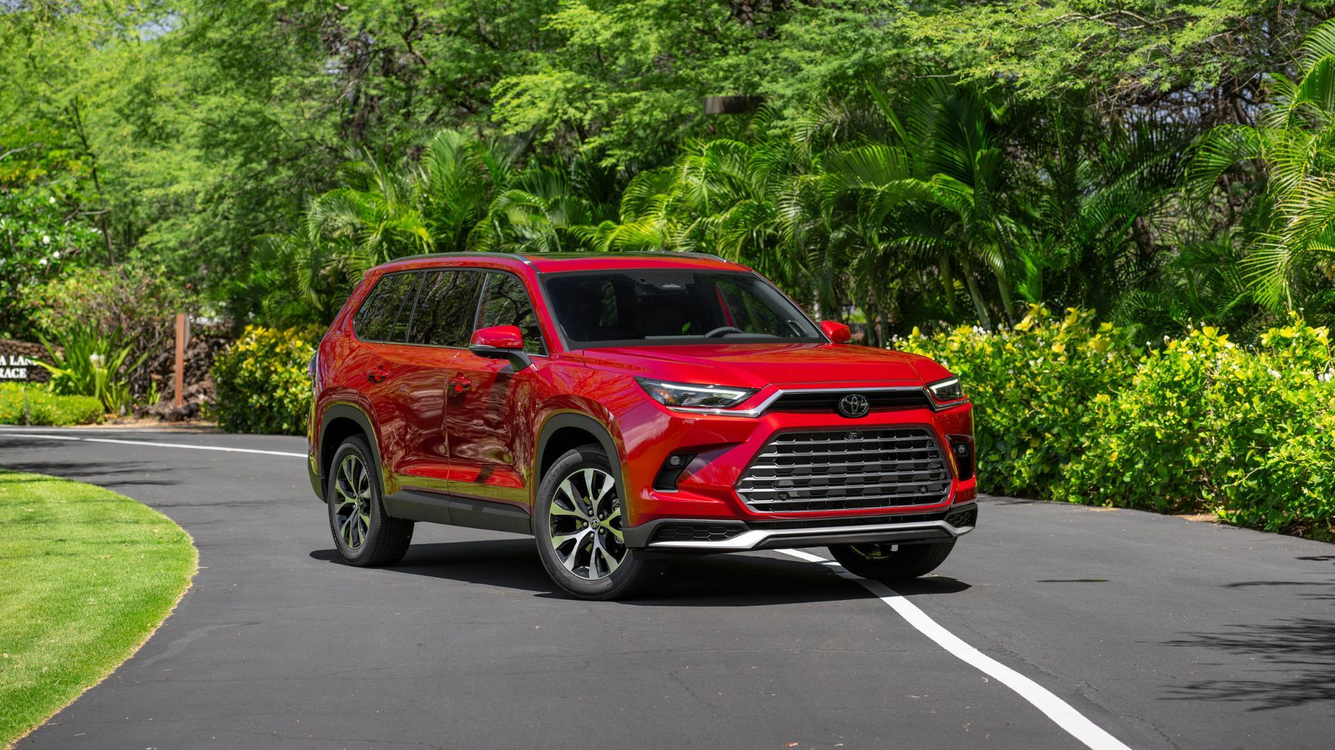 Static 3/4 front shot of a red 2026 Toyota Grand Highlander.