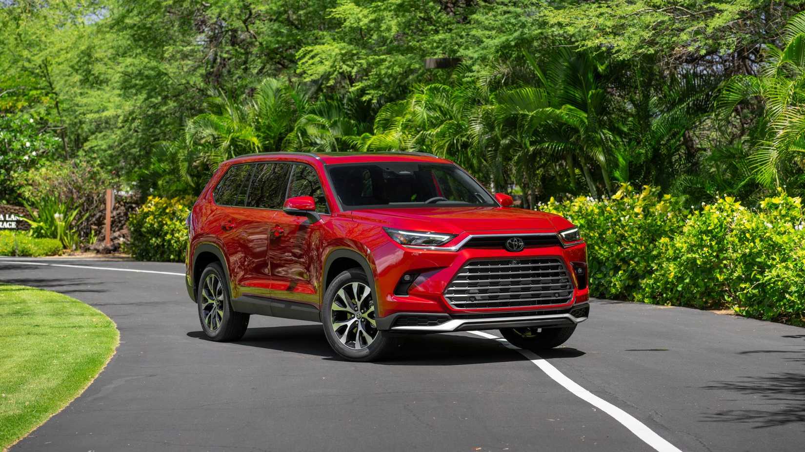 Static front 3/4 shot of a red 2026 Toyota Grand Highlander.