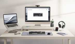 A desktop set up with a laptop and headphones with an Alto Keys K98M in the middle