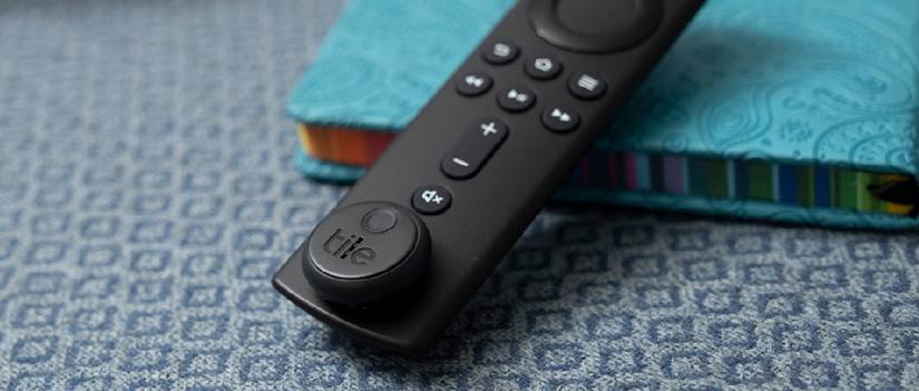 TV remote control with a plate sticker attached at the bottom.