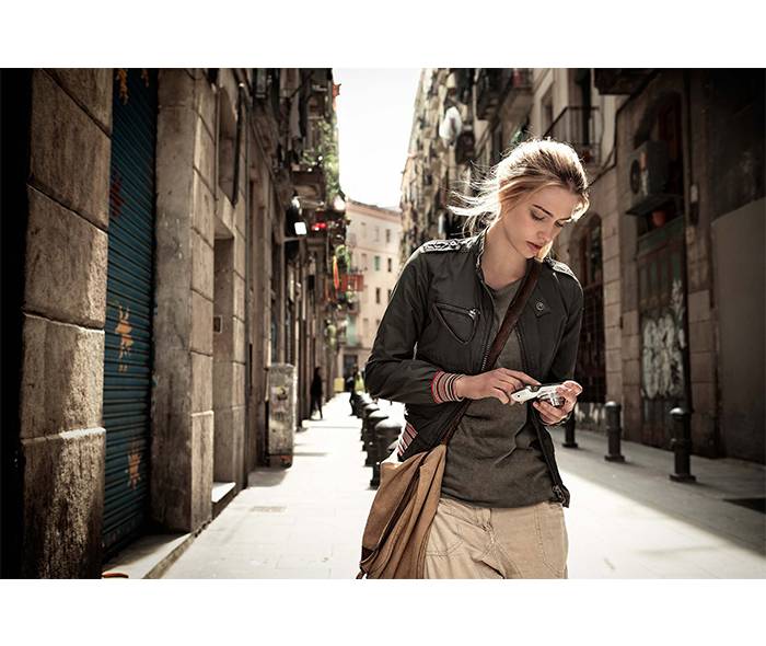 A woman walks the street using her S4 Zoom phone.