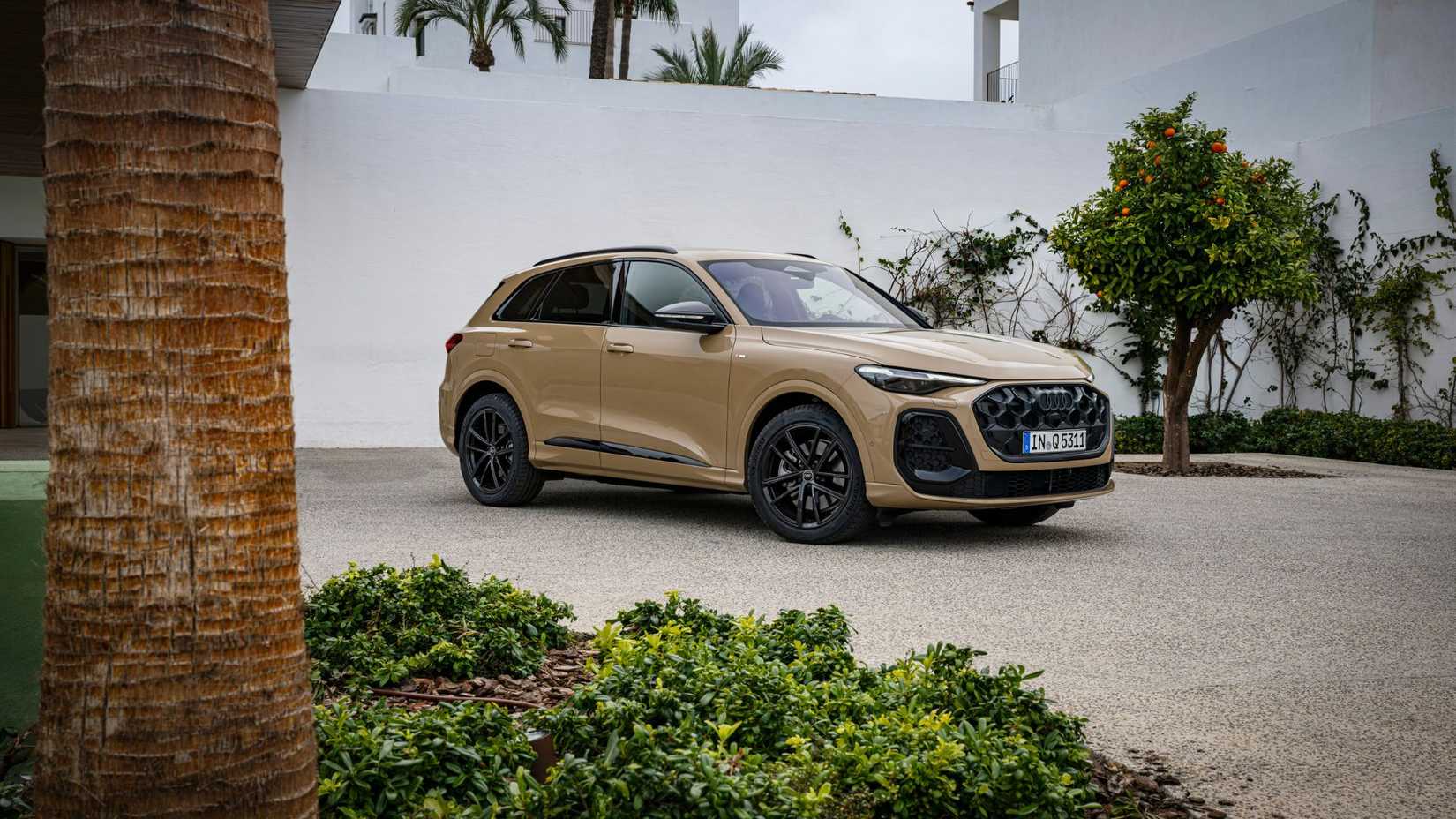 Static front 3/4 shot of a beige Audi Q5.