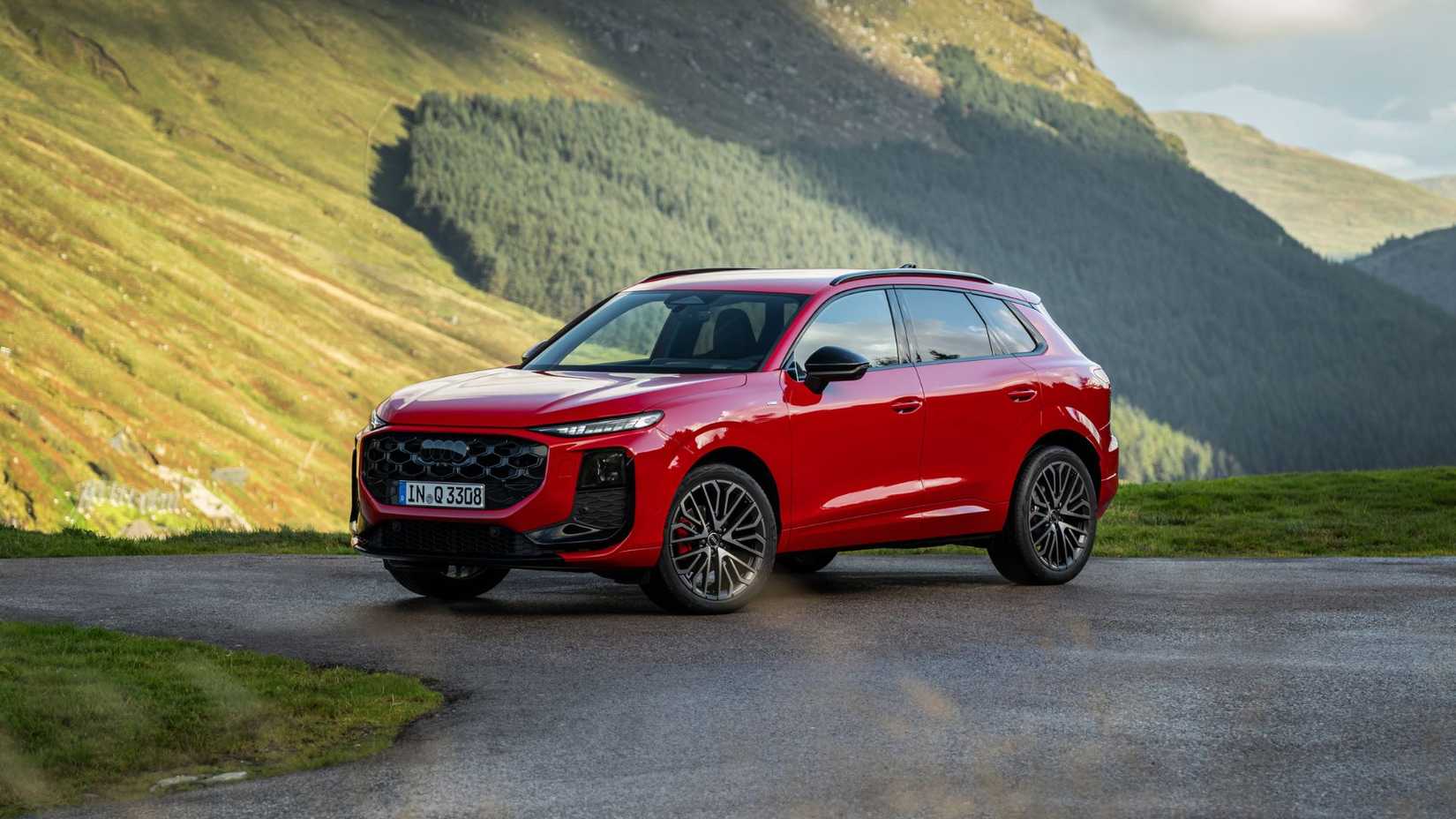 Static front 3/4 shot of a red 2026 Audi Q3.