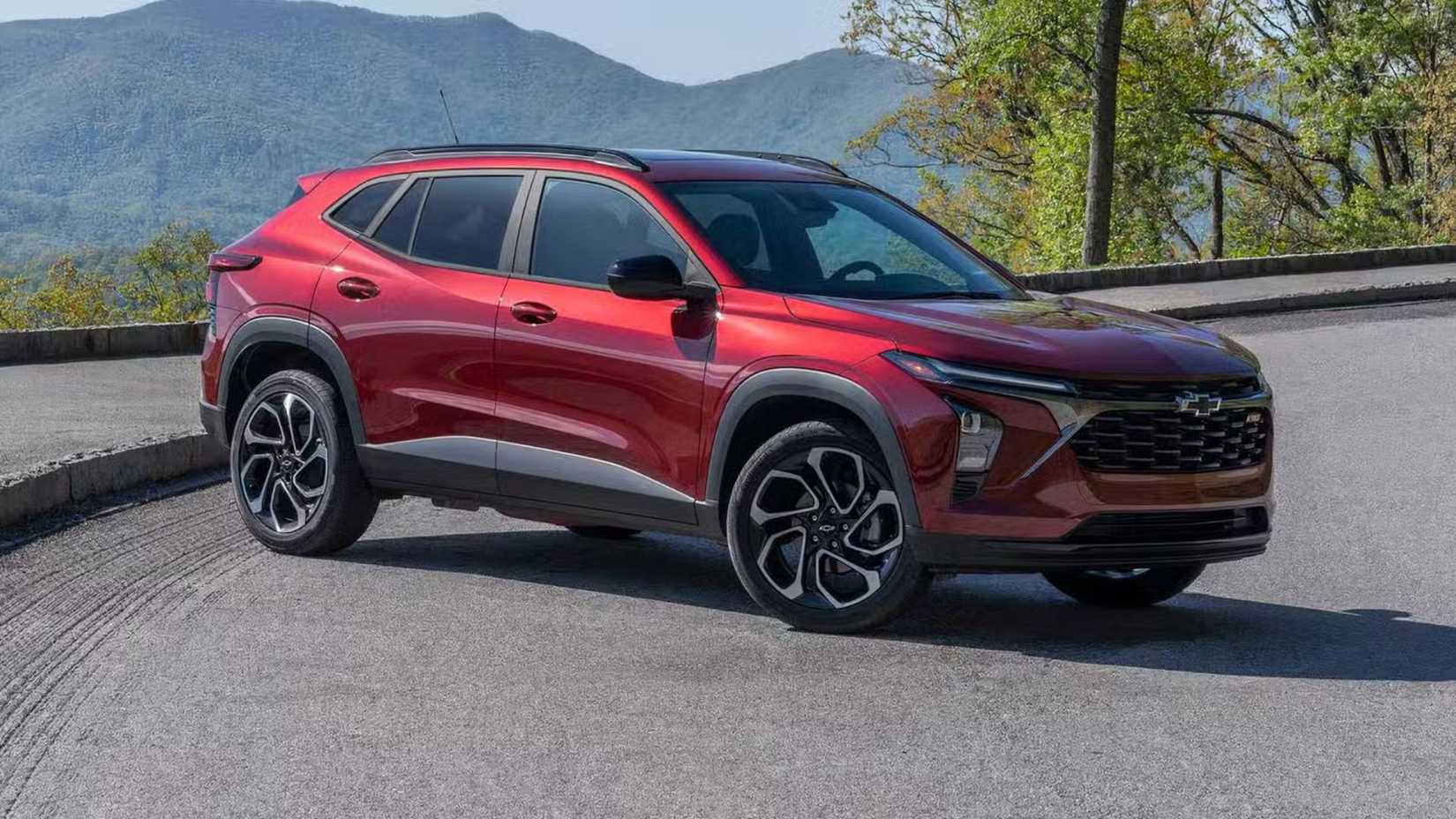 Static front 3/4 shot of 2024 Chevrolet Trax 2RS in red parked in front of a mountain range.