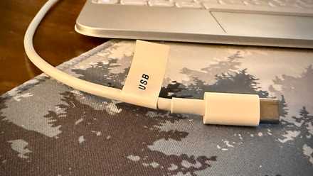 White USB-C cable labeled with a USB tag.