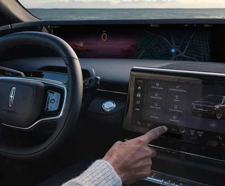 Shot of a male driver using the central touchscreen in a 2024 Lincoln Nautilus.