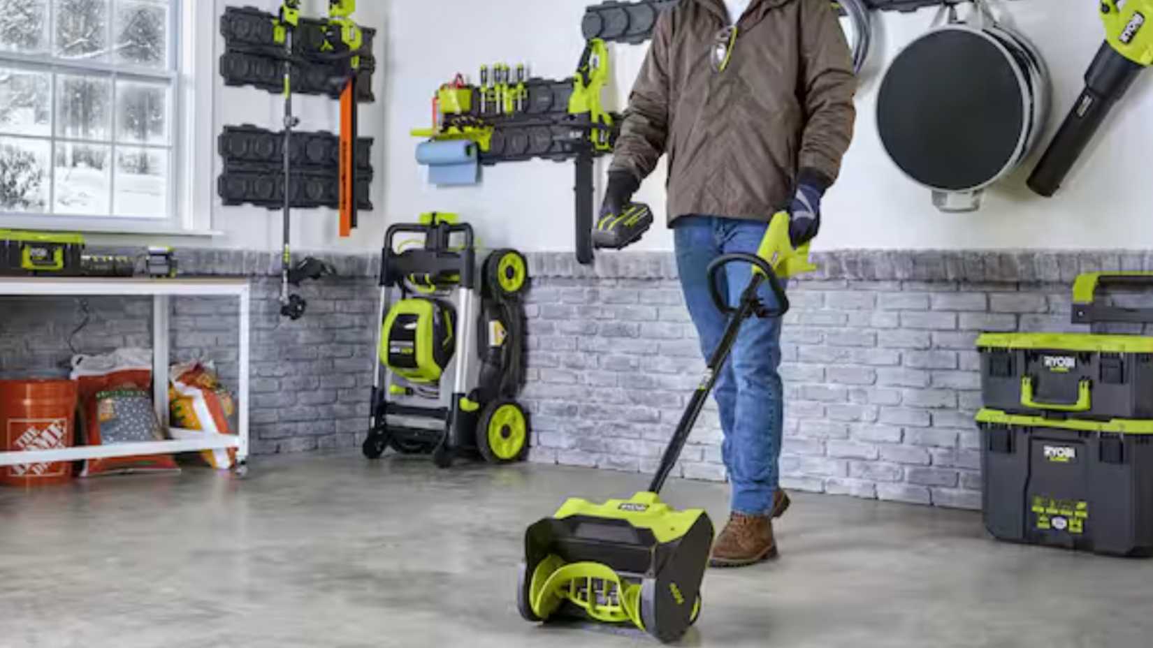 Man holding a Ryobi electric shovel in a garage