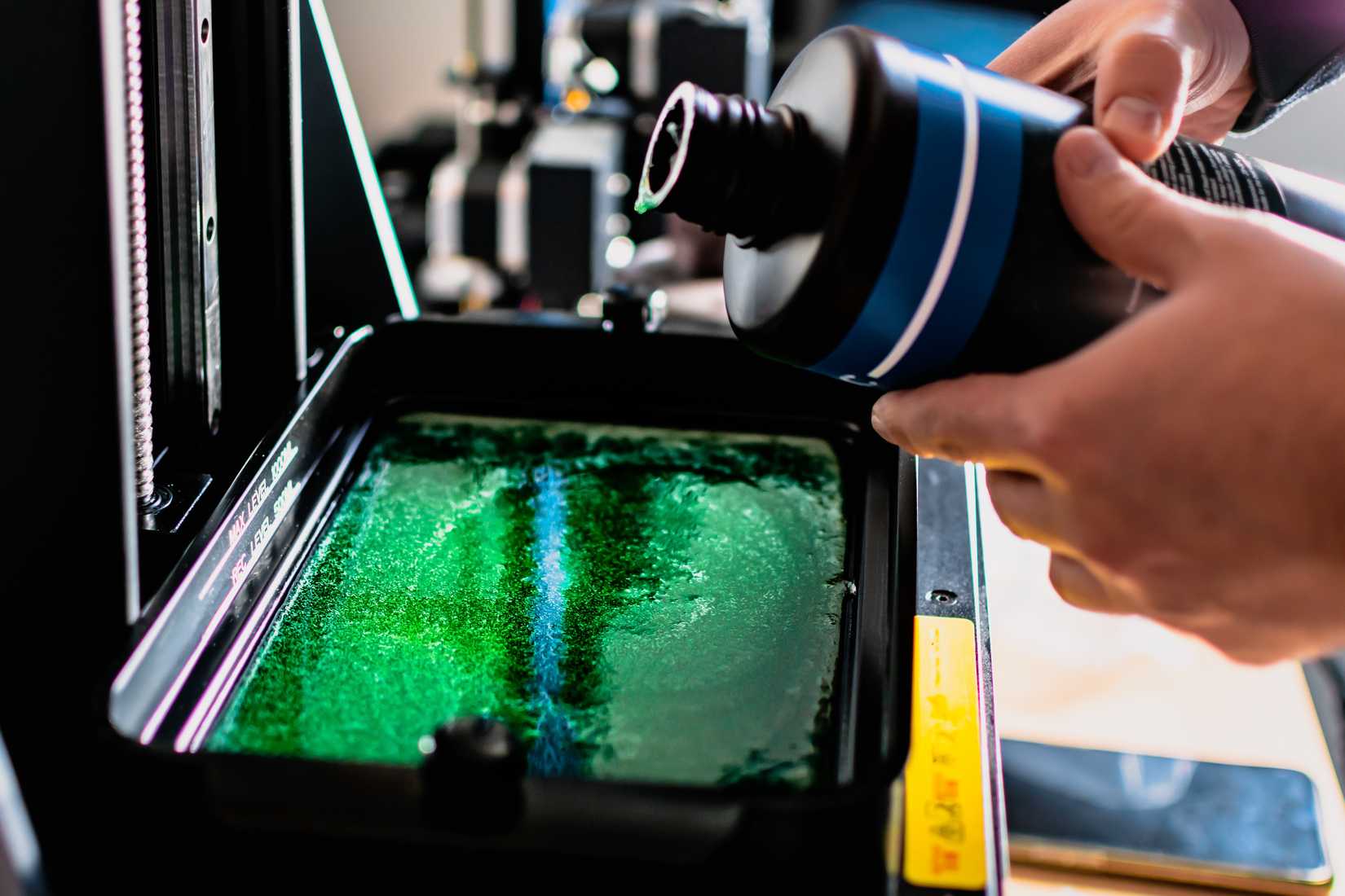 Resin being poured into a 3D printer.