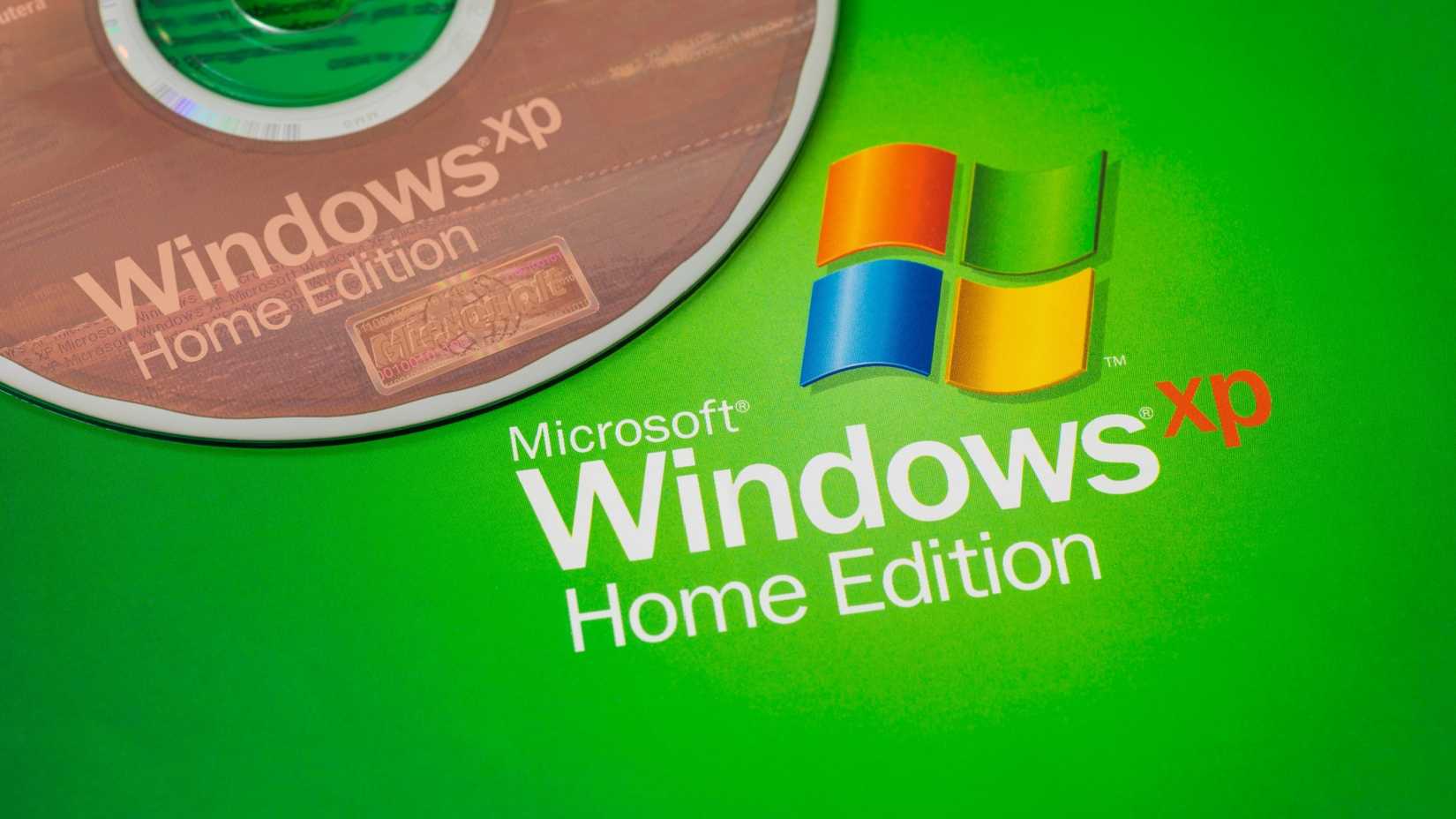 Um disco do Windows XP próximo ao logotipo do Windows XP.