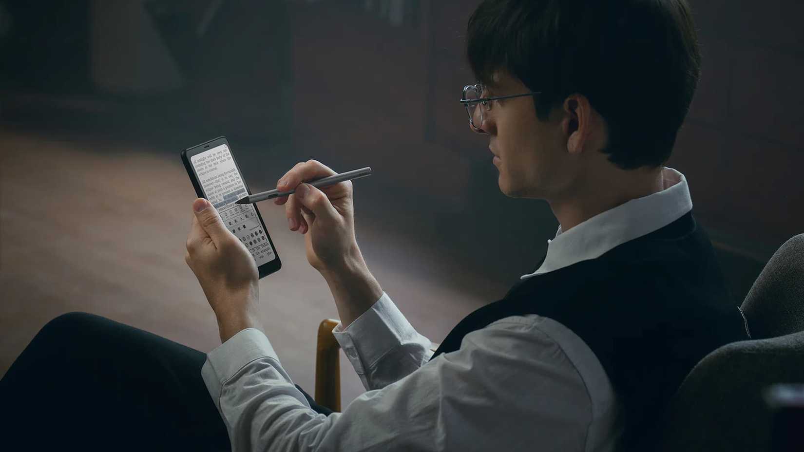 Мужчина с BOOX Palma 2 Pro в руках сидит в кресле