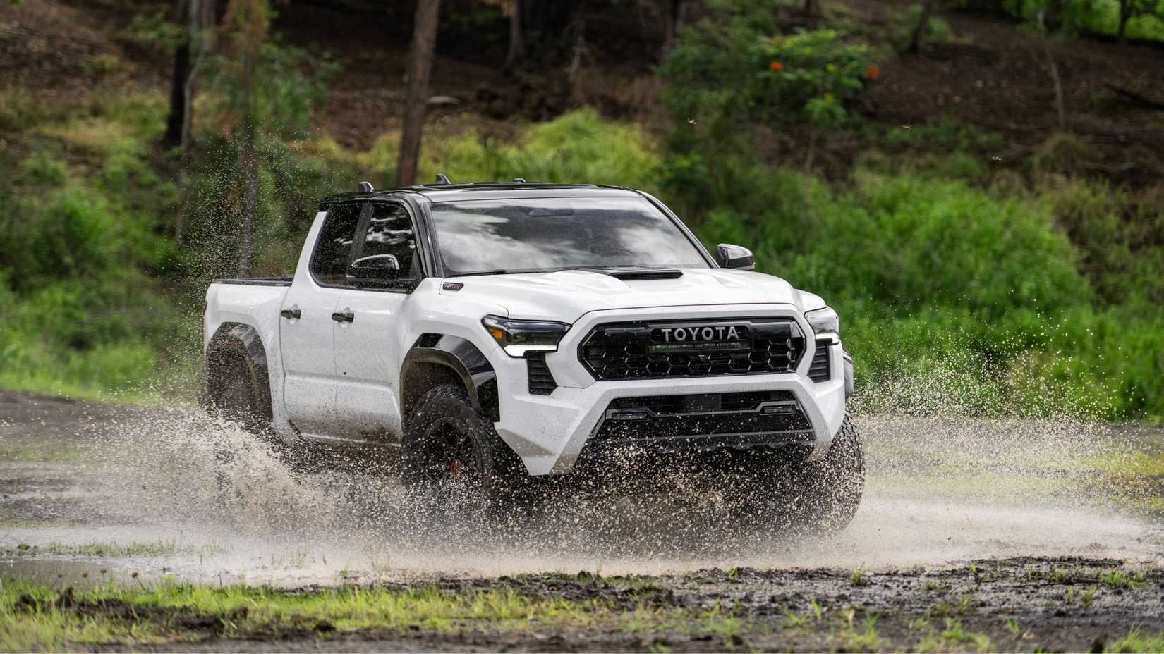 Dynamic front 3/4 shot of a white 2024 Toyota Tacoma TRD Pro.