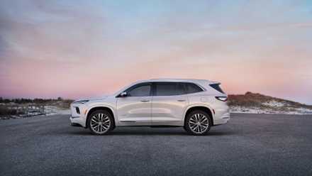 Fail to remember the Lexus NX—This American SUV gives extra price for much less cash Static side profile shot of a white 2025 Buick Enclave Avenir parked on tarmac.