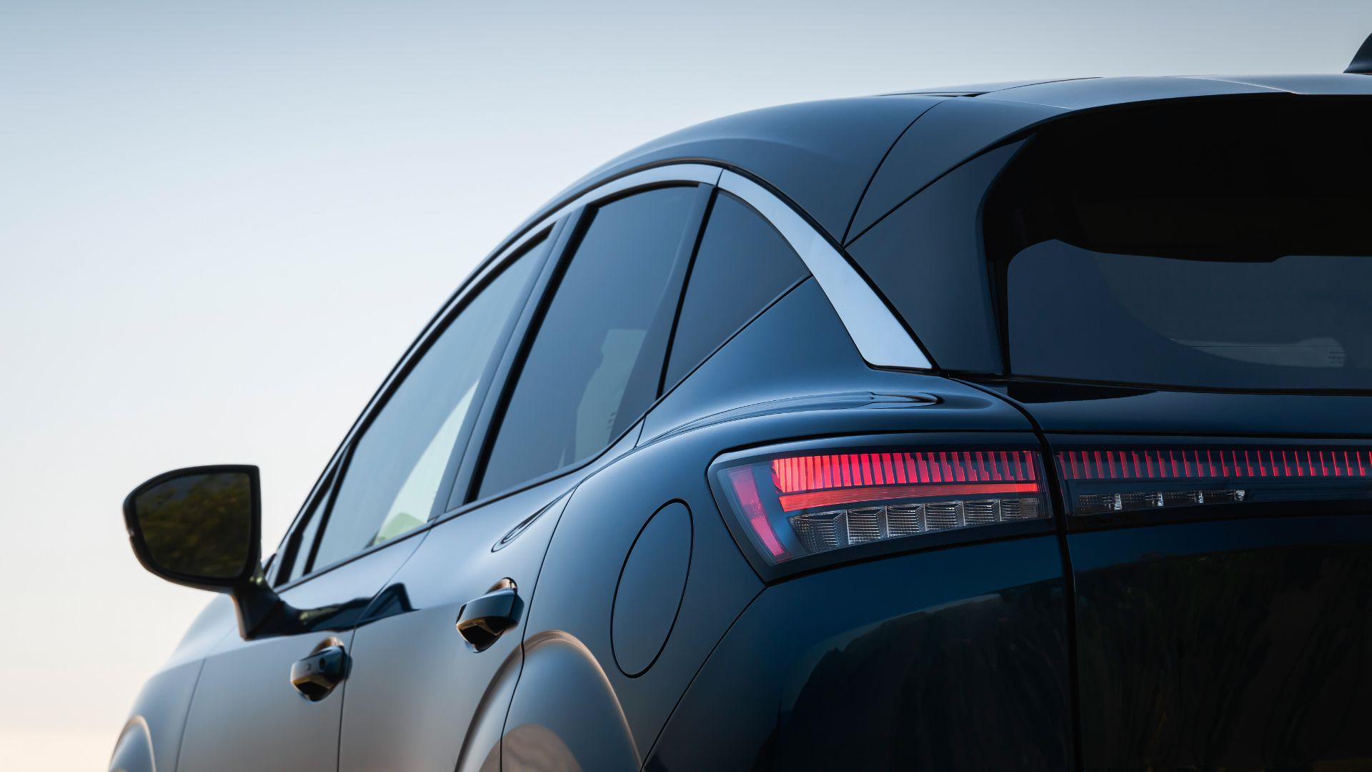 Close-up rear 3/4 shot of a dark colored 2025 Nissan Murano.