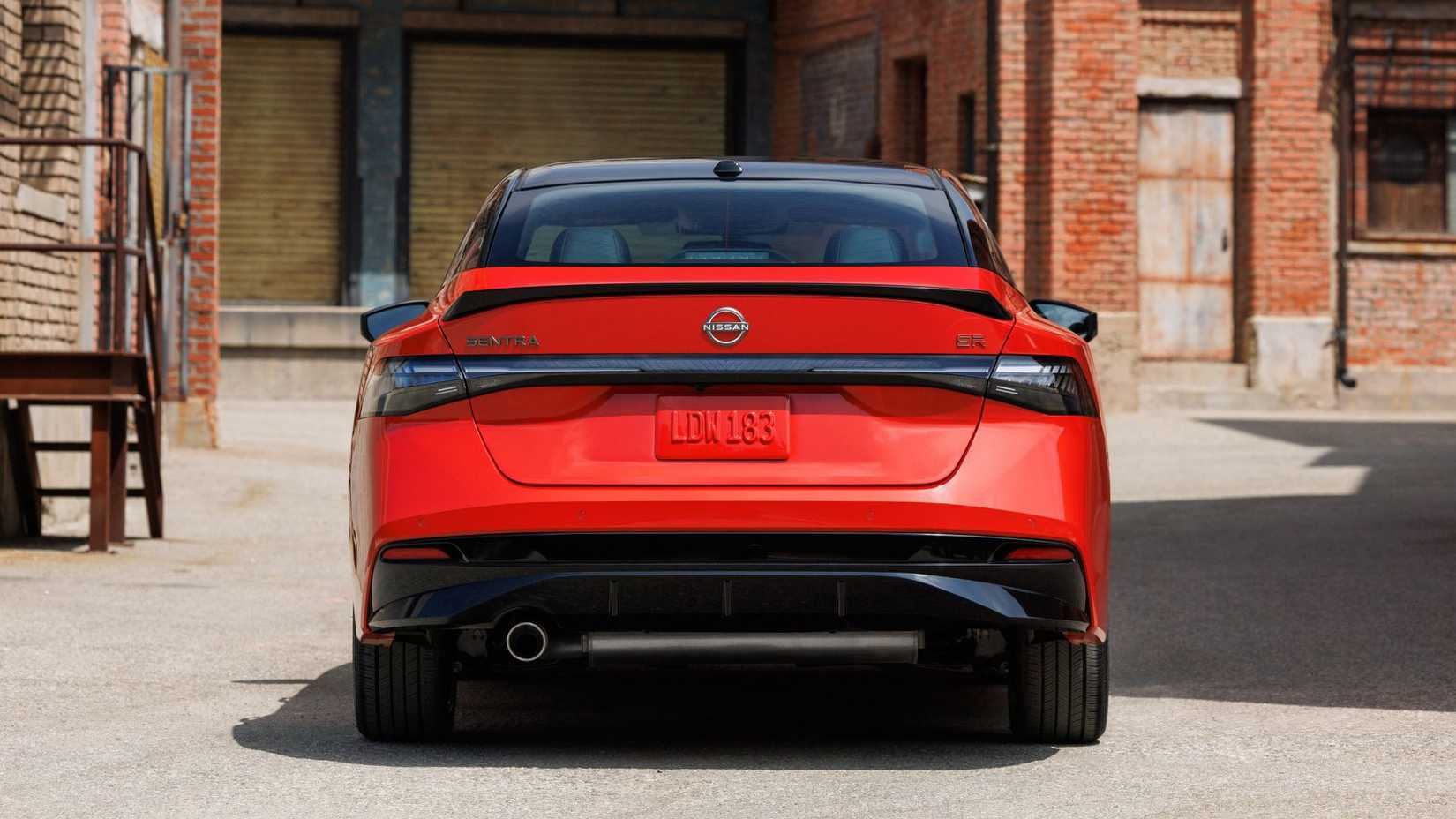 Static rear-end shot of a red 2026 Nissan Sentra parked in a city.