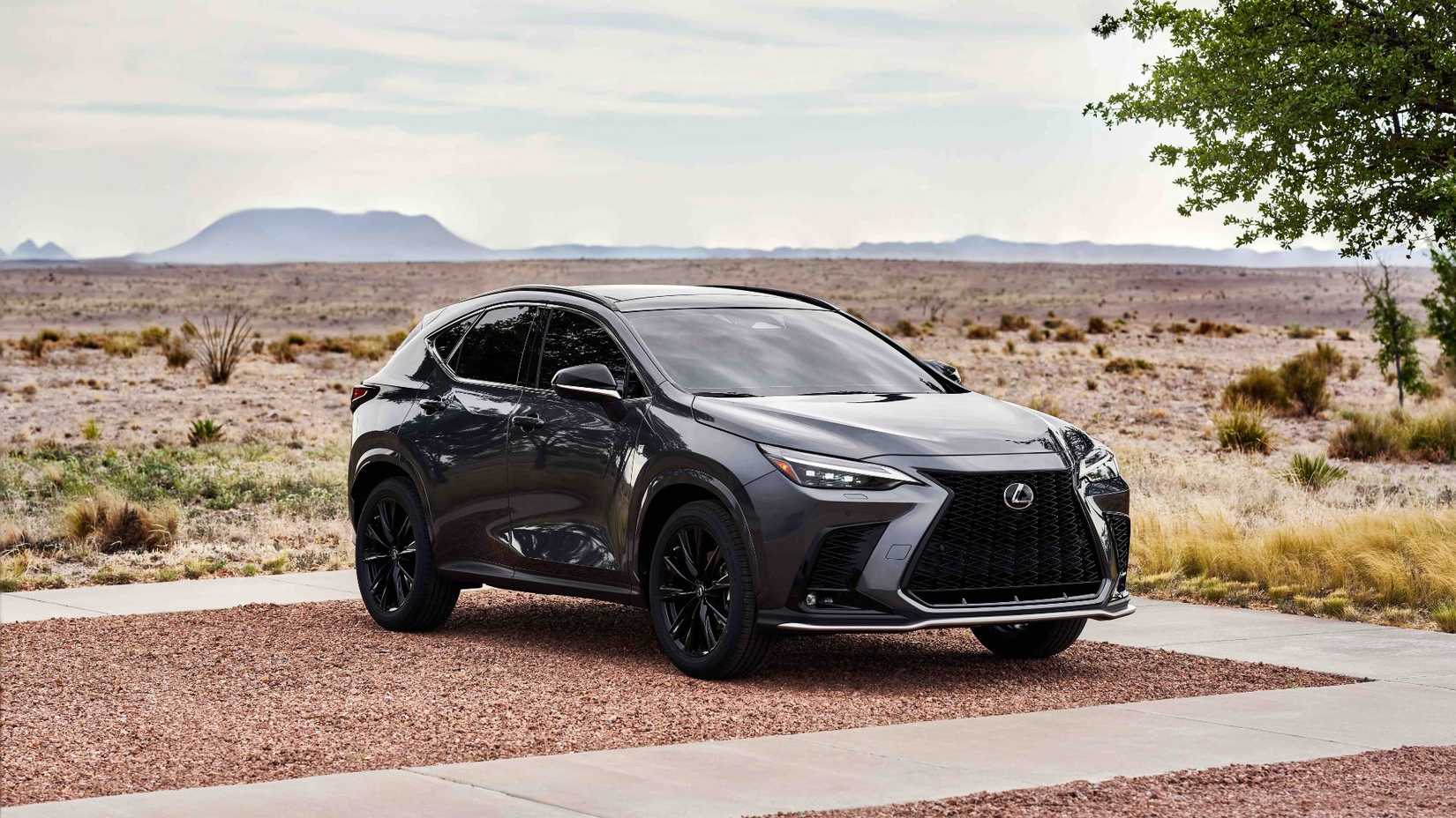 Static front 3/4 shot of a gray 2026 Lexus NX 350 FSPORT parked on gravel.
