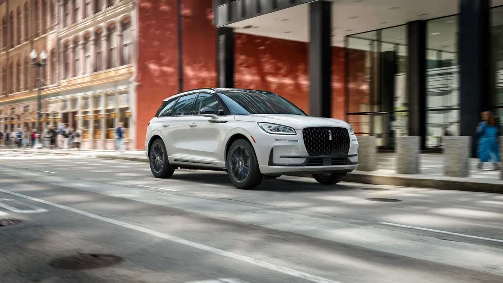 Dynamic front 3/4 shot of a white 2026 Lincoln Corsair driving in a city.