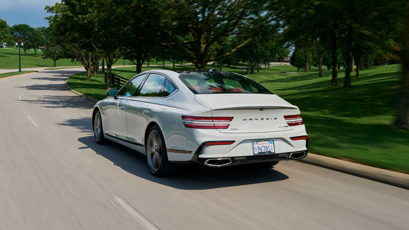 Dynamic rear 3/4 shot of a white 2025 Genesis G80.