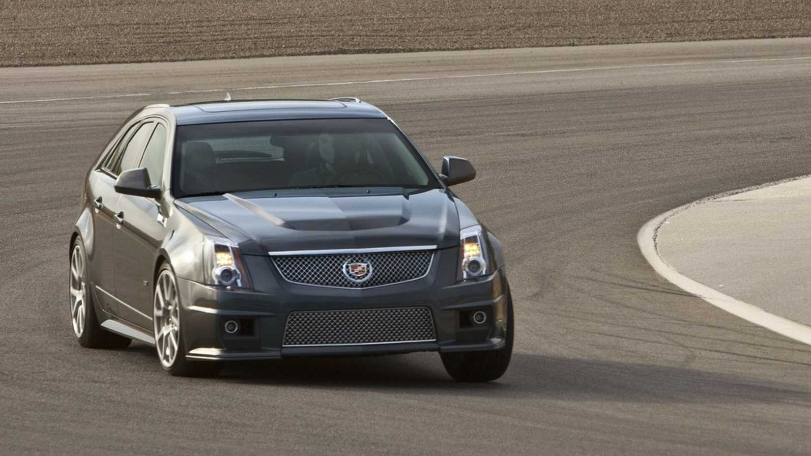 Dynamic front 3/4 shot of a gray 2011 Cadillac CTS-V Wagon driving on a racetrack.
