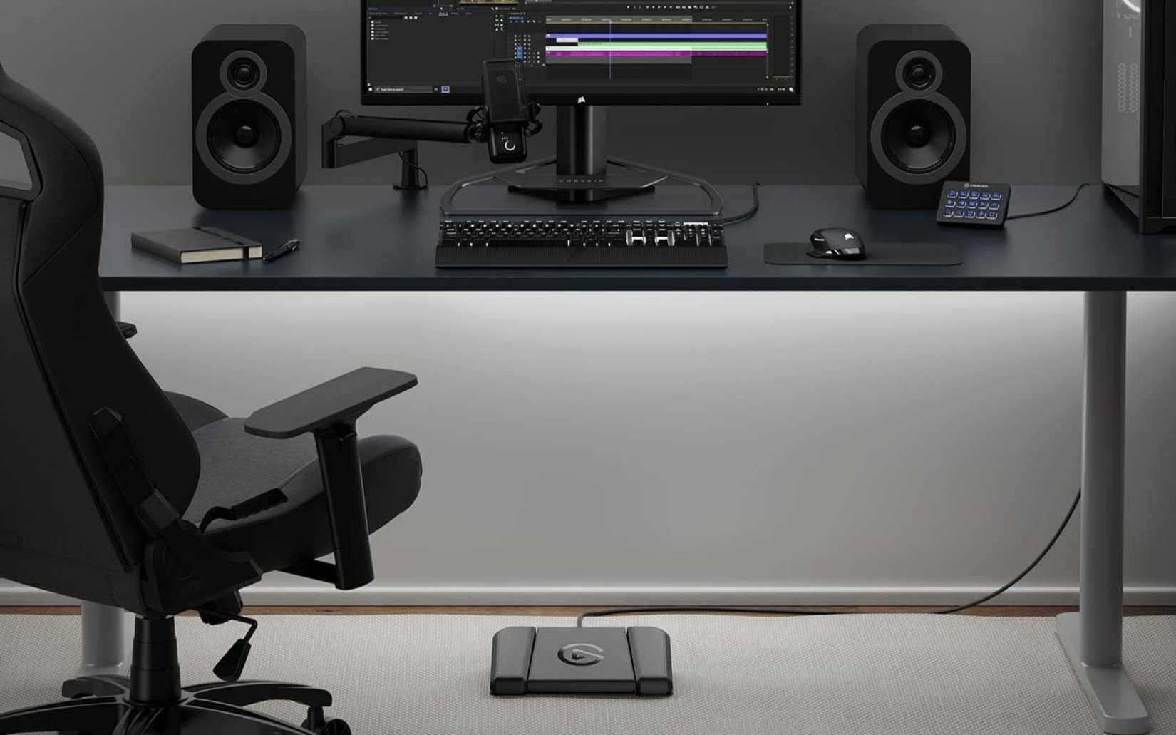 An Elgato Stream Deck USB Pedal placed underneath a computer desk. 