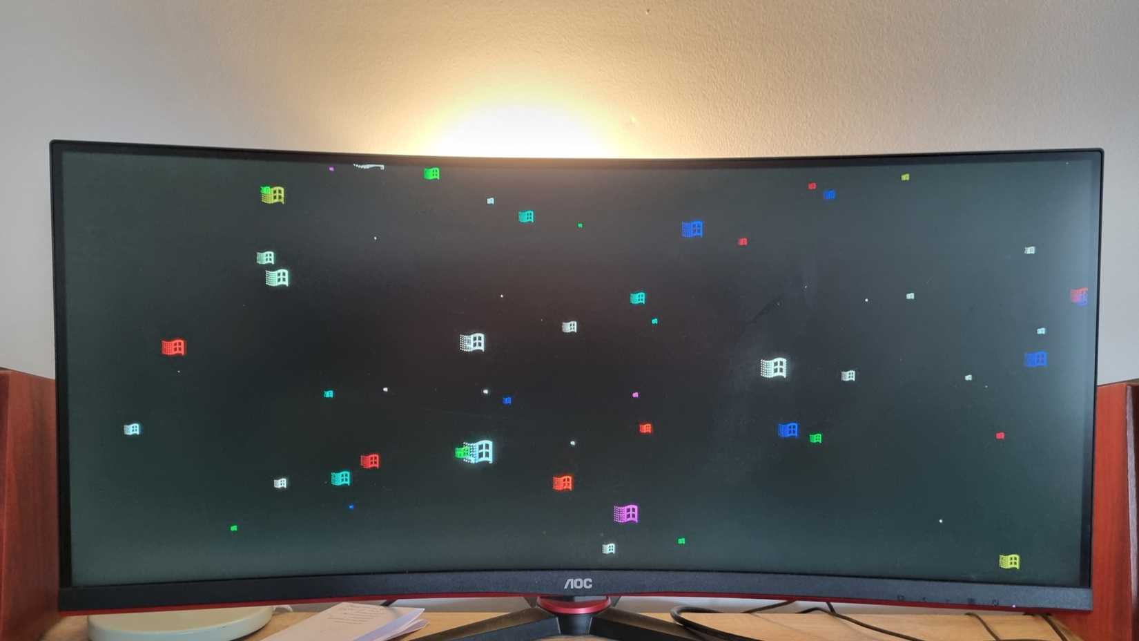 The Flying Windows Windows 98 screensaver running on an ultrawide monitor. 