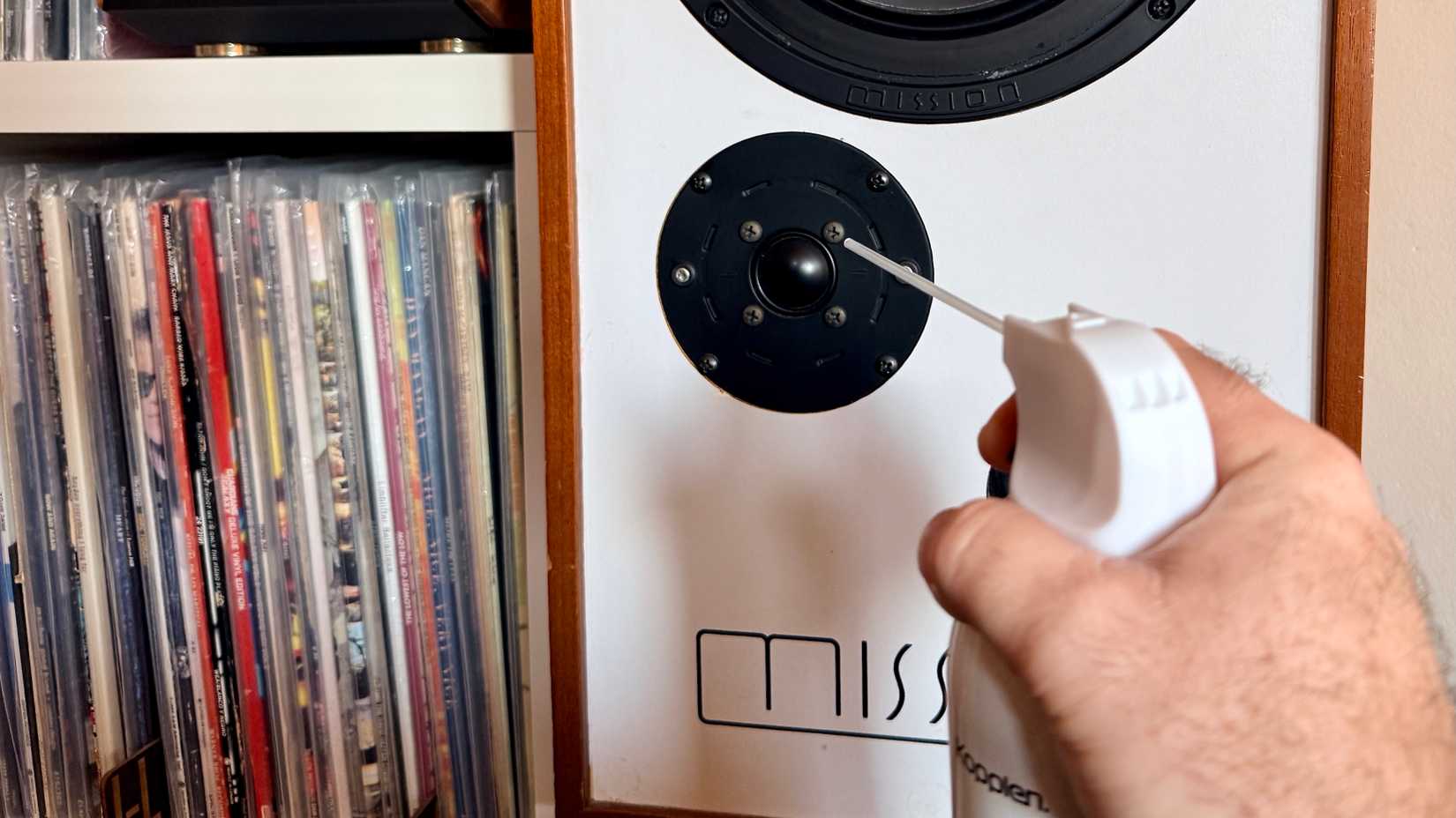 Someone cleaning a tweeter with compressed air.