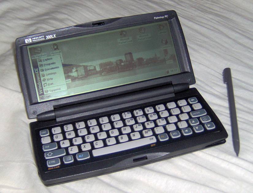 A HP 300LX hpc with stylus, showing Windows CE 1.0. The wallpaper shows the skyline of the Norwegian city of Bergen.