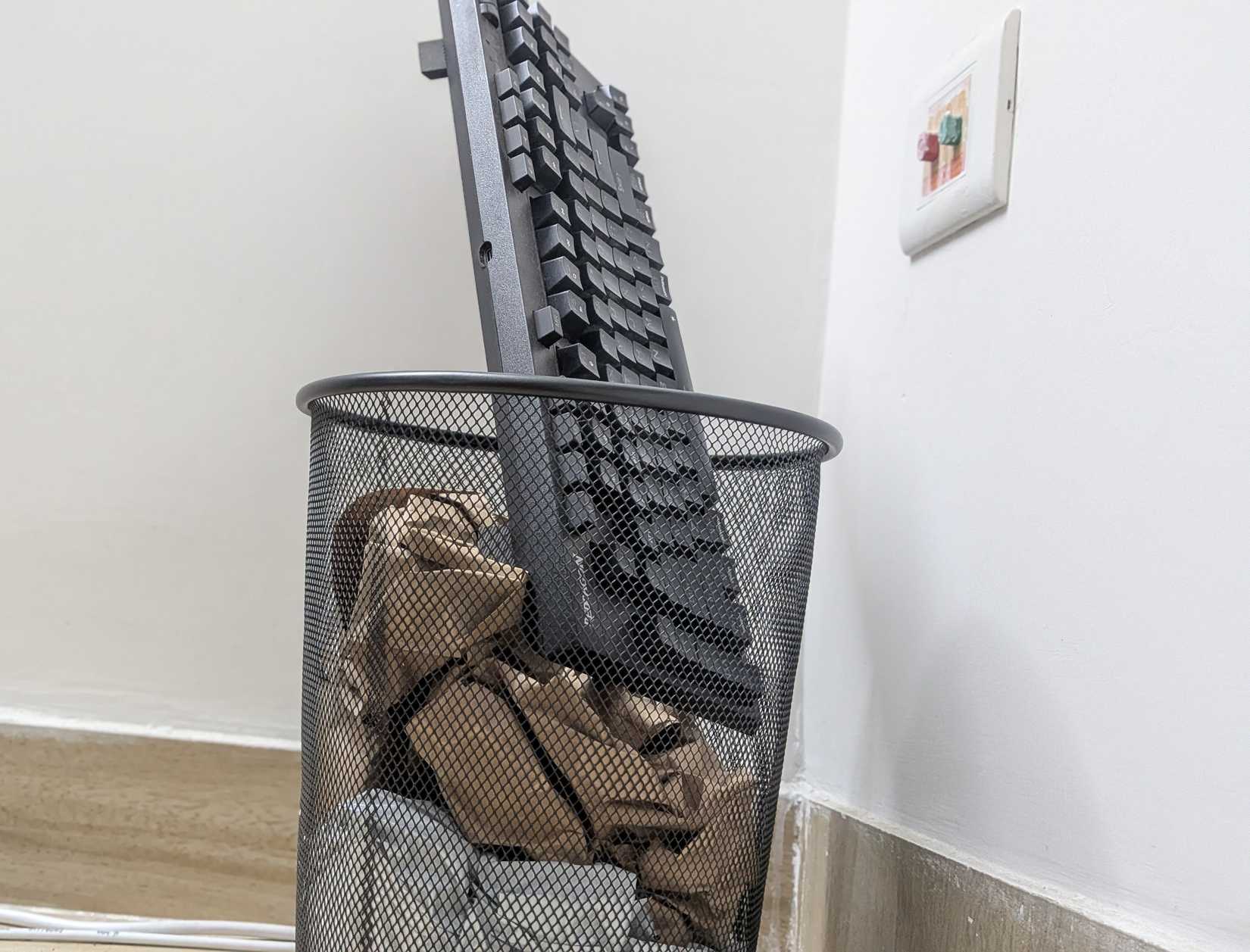 Keyboard in a trashbin.