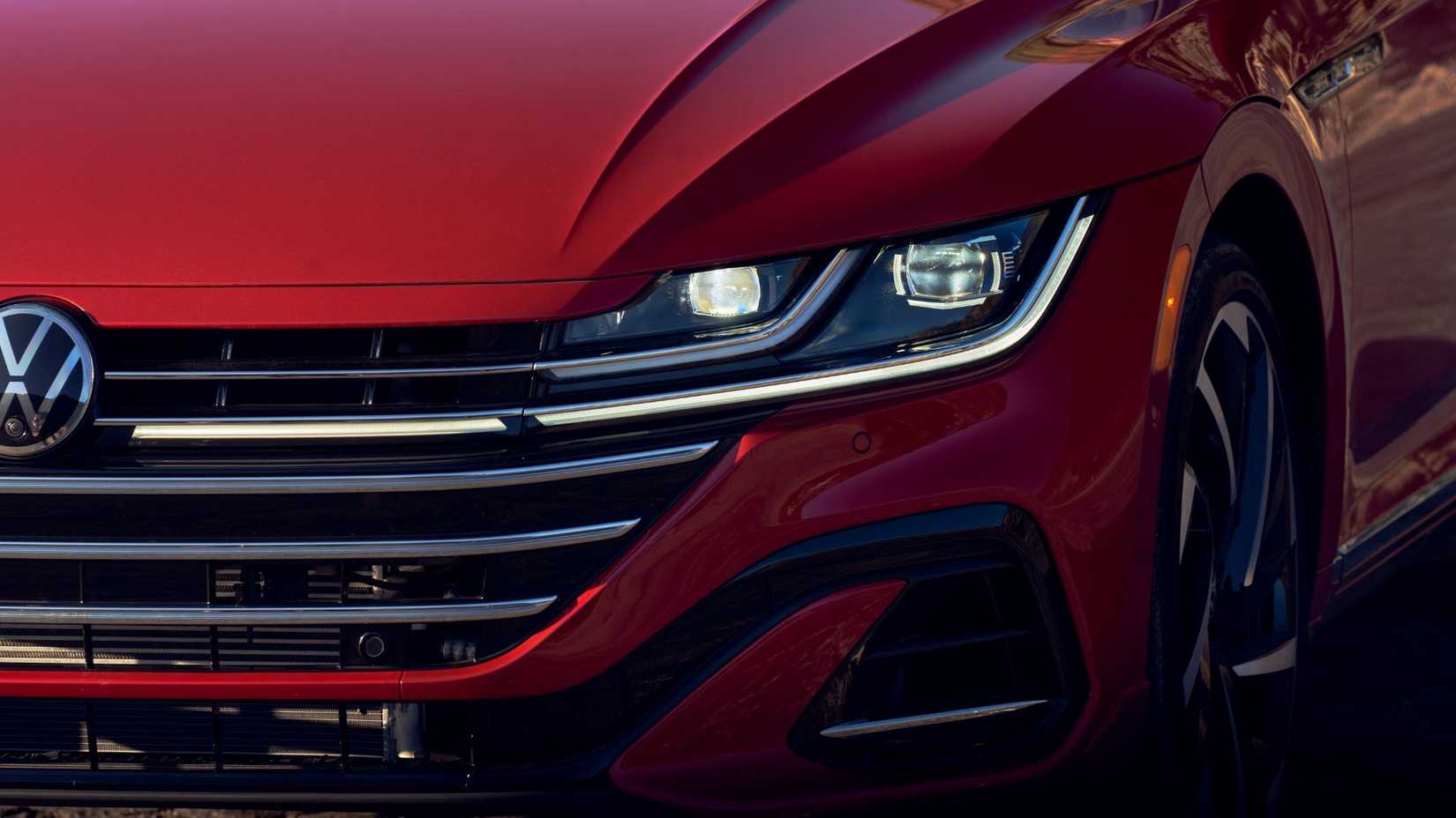 Close-up shot of the headlight and front grille on a red 2021 Volkswagen Arteon.