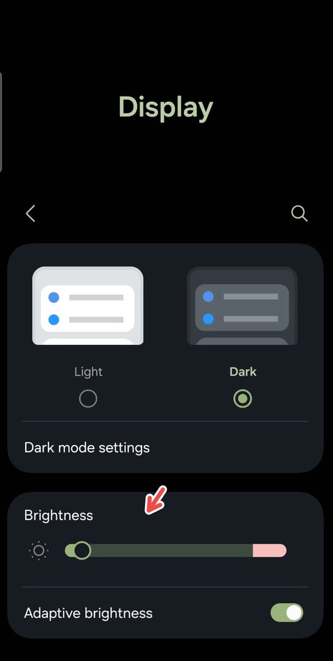 A screenshot on an Android device showing a red arrow pointing to the Brightness setting.