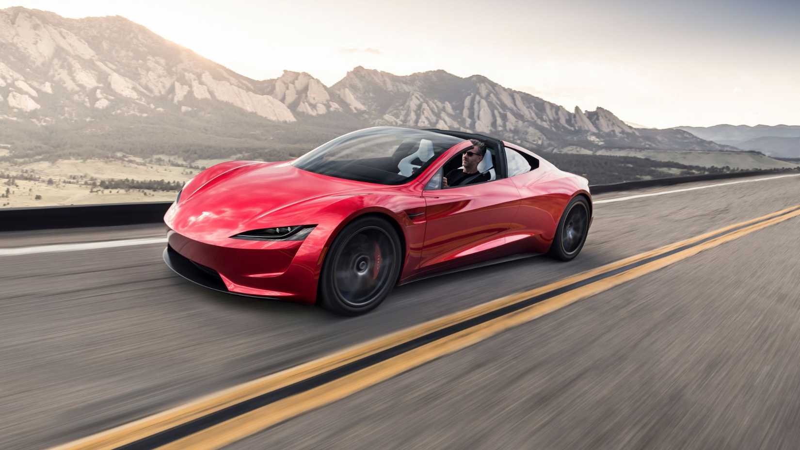 Dynamic front 3/4 shot of a red Tesla Roadster.