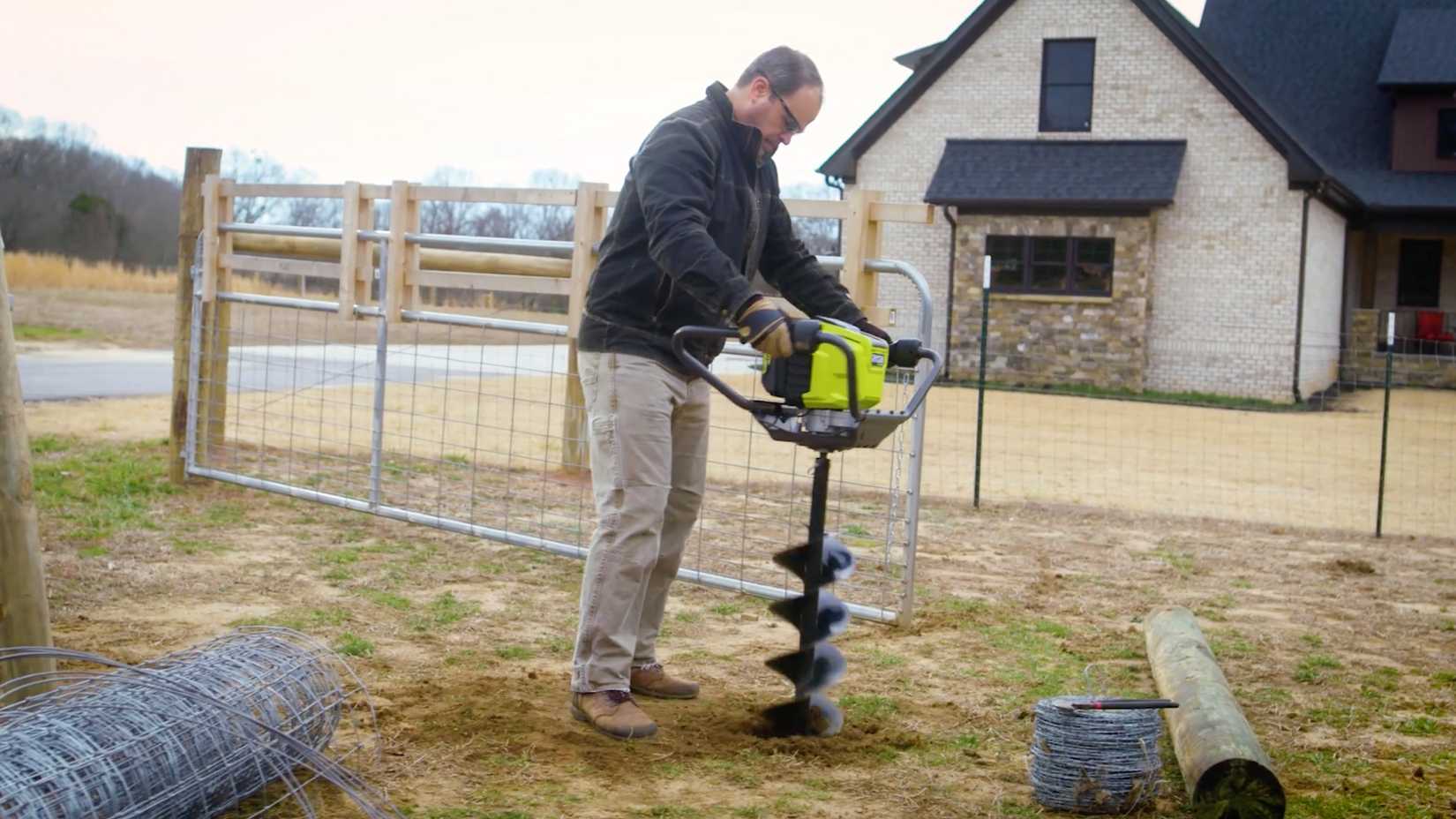 Земляной бур Ryobi Мужчина использует земляной бур Ryobi