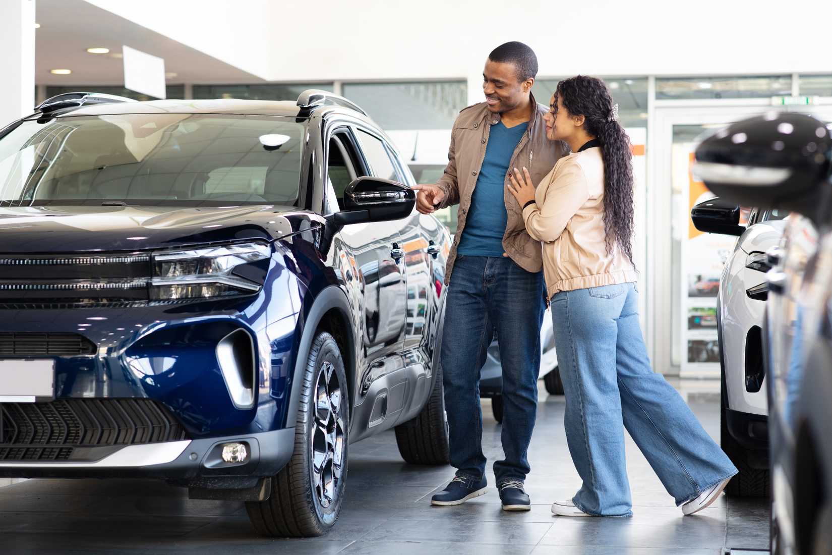A couple examine an SUV before purchase.