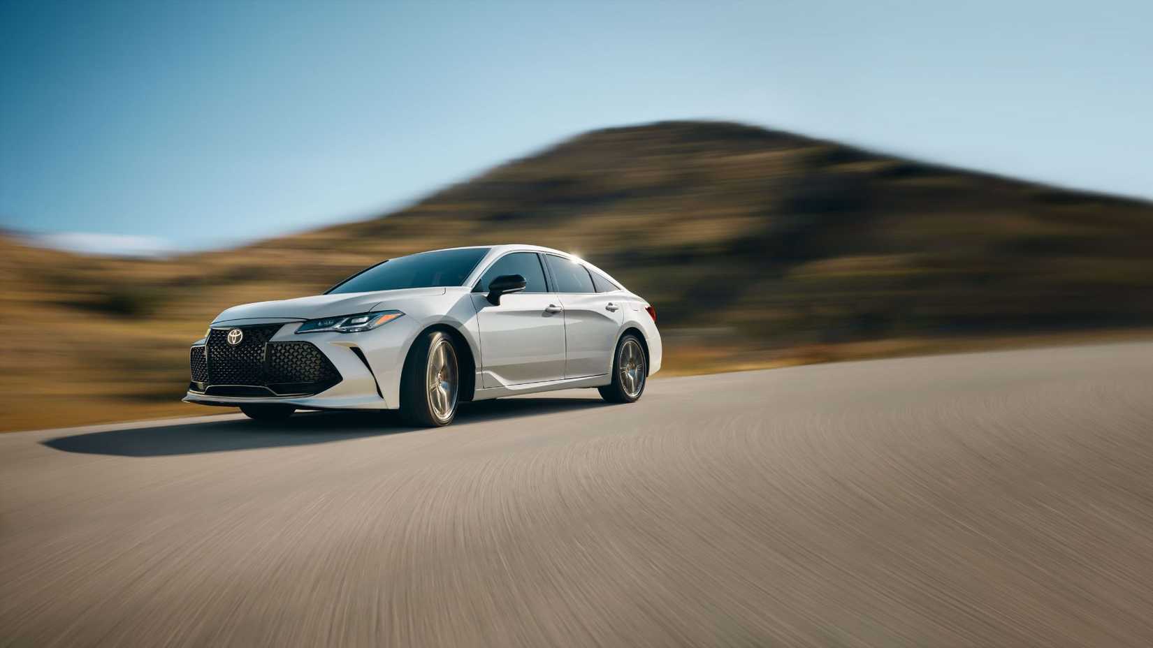 Dynamic front 3/4 shot of a white 2022 Toyota Avalon Touring.