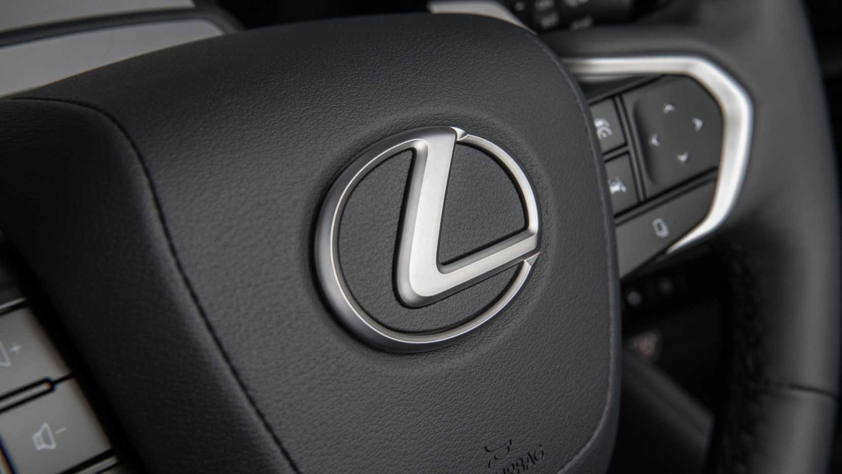 Primer plano de la insignia en el volante de un Lexus TX 350 Premium 2026.