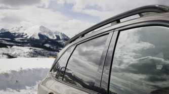 Close-up shot of the side of a 2026 Kia Sorento with a snow-capped mountain in the background.