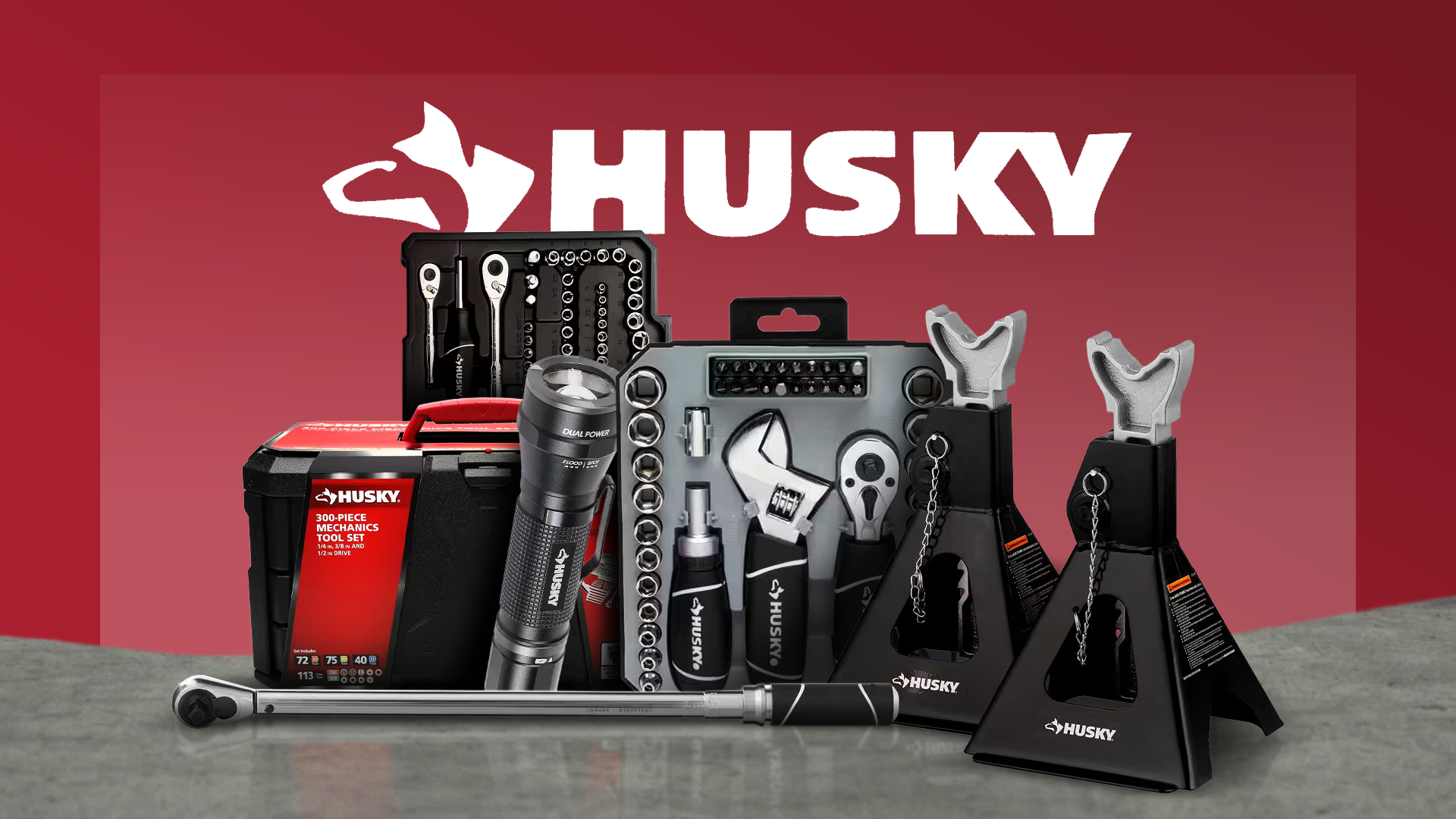 A collage of Husky tools, including a stubby ratchet and socket set, two floor jacks, an aluminum flashlight, a drive torque wrench, and a mechanics tool set, against a red background with the Husky logo.
