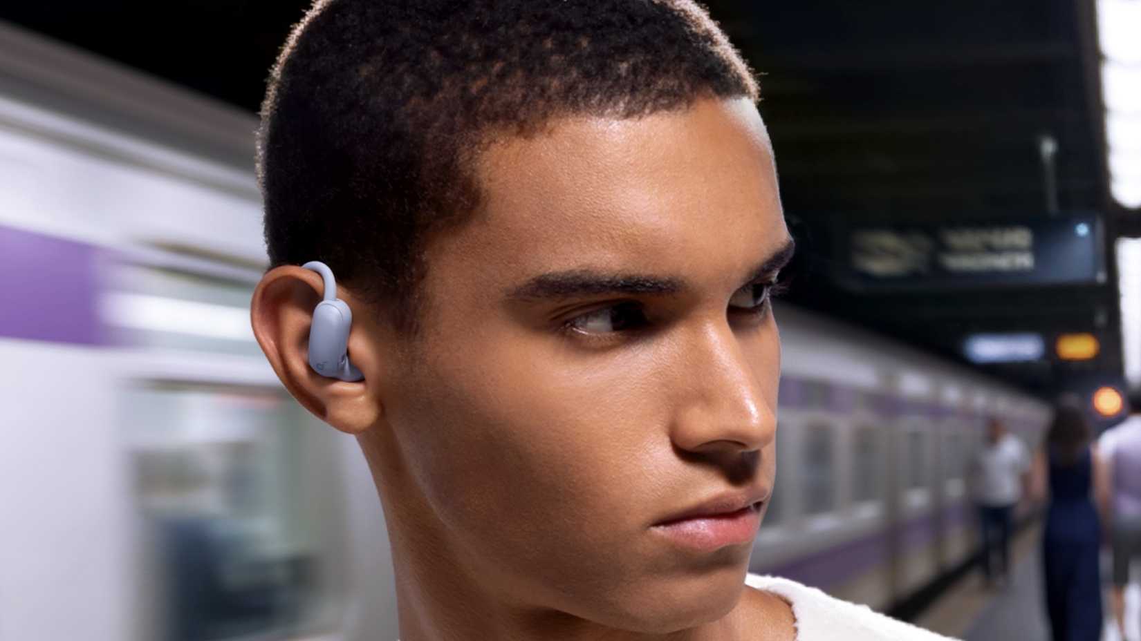 AeroFit 2 Pro in the ear of a man in a train station.