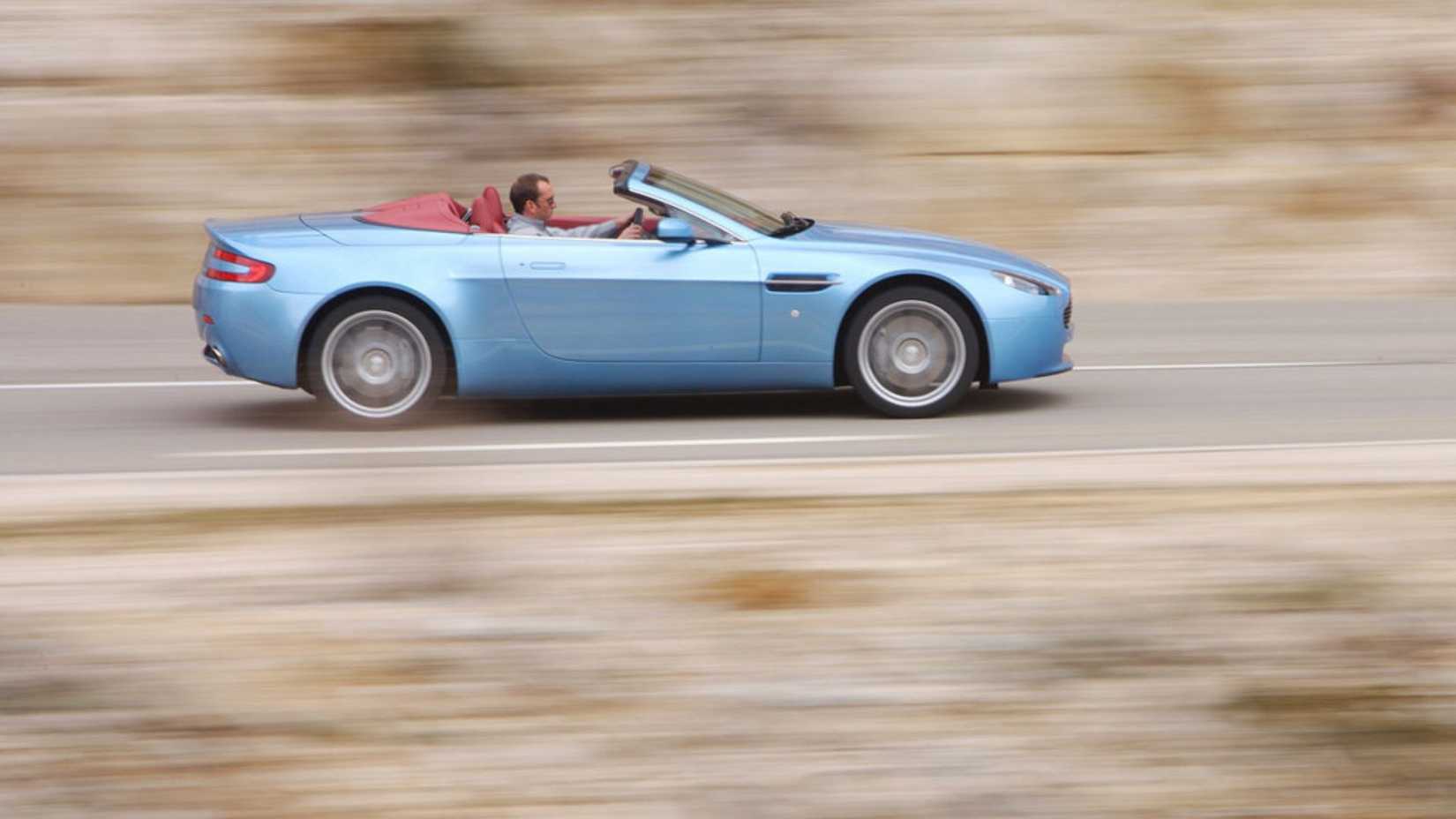 Dynamic side profile photo of a blue 2007 Aston Martin V8 Vantage Roadster.