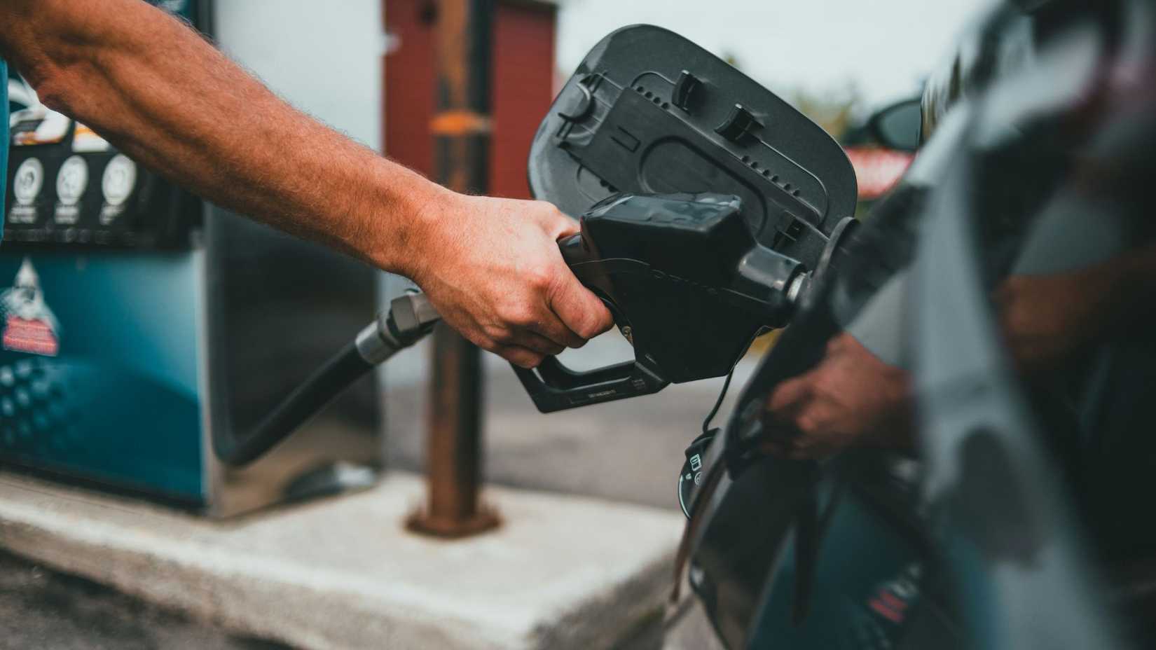 Shot of a man refueling a car at a gas station.