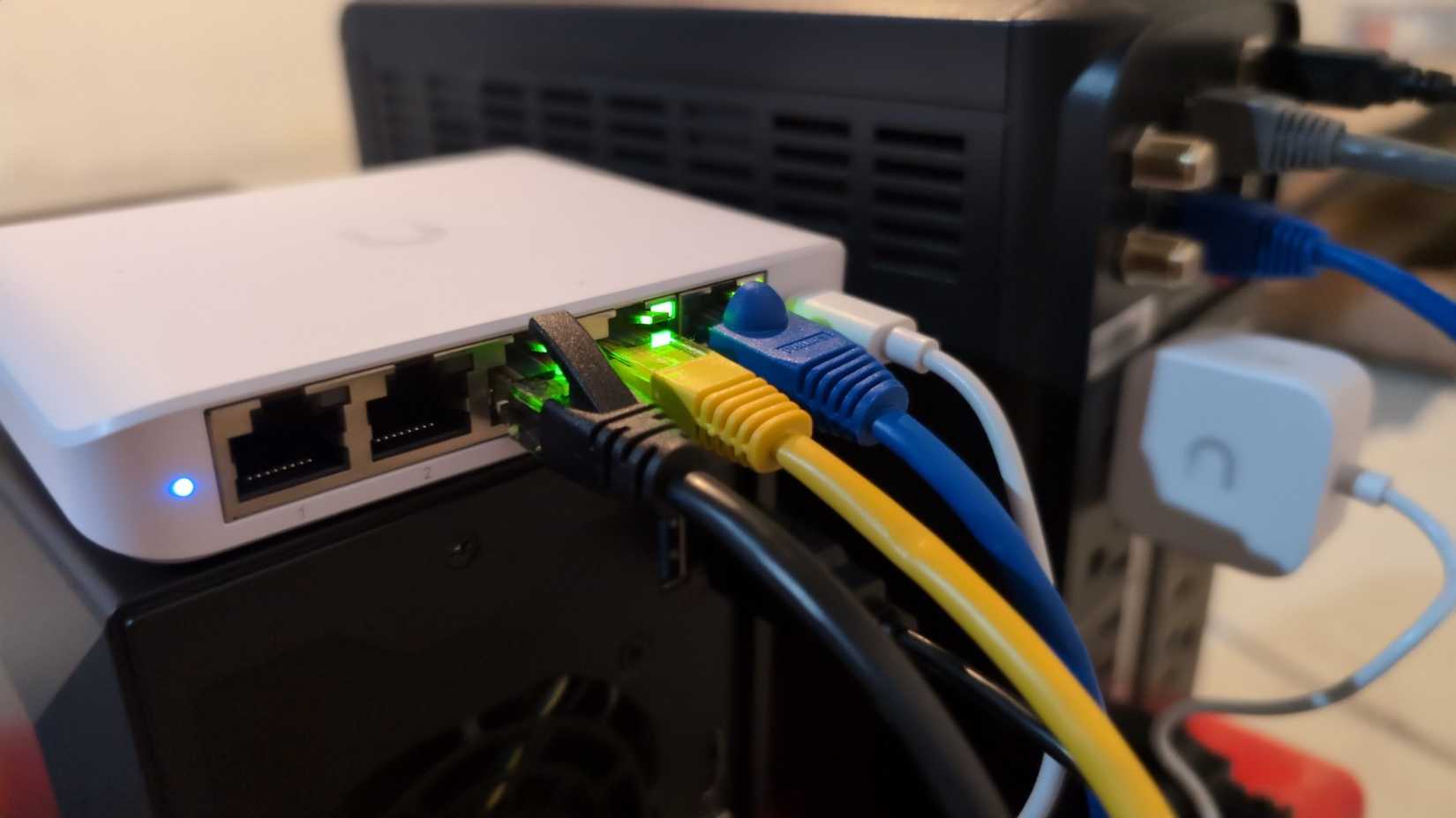 Ethernet cables plugged into a Ubiquiti Flex Mini managed network switch.-2