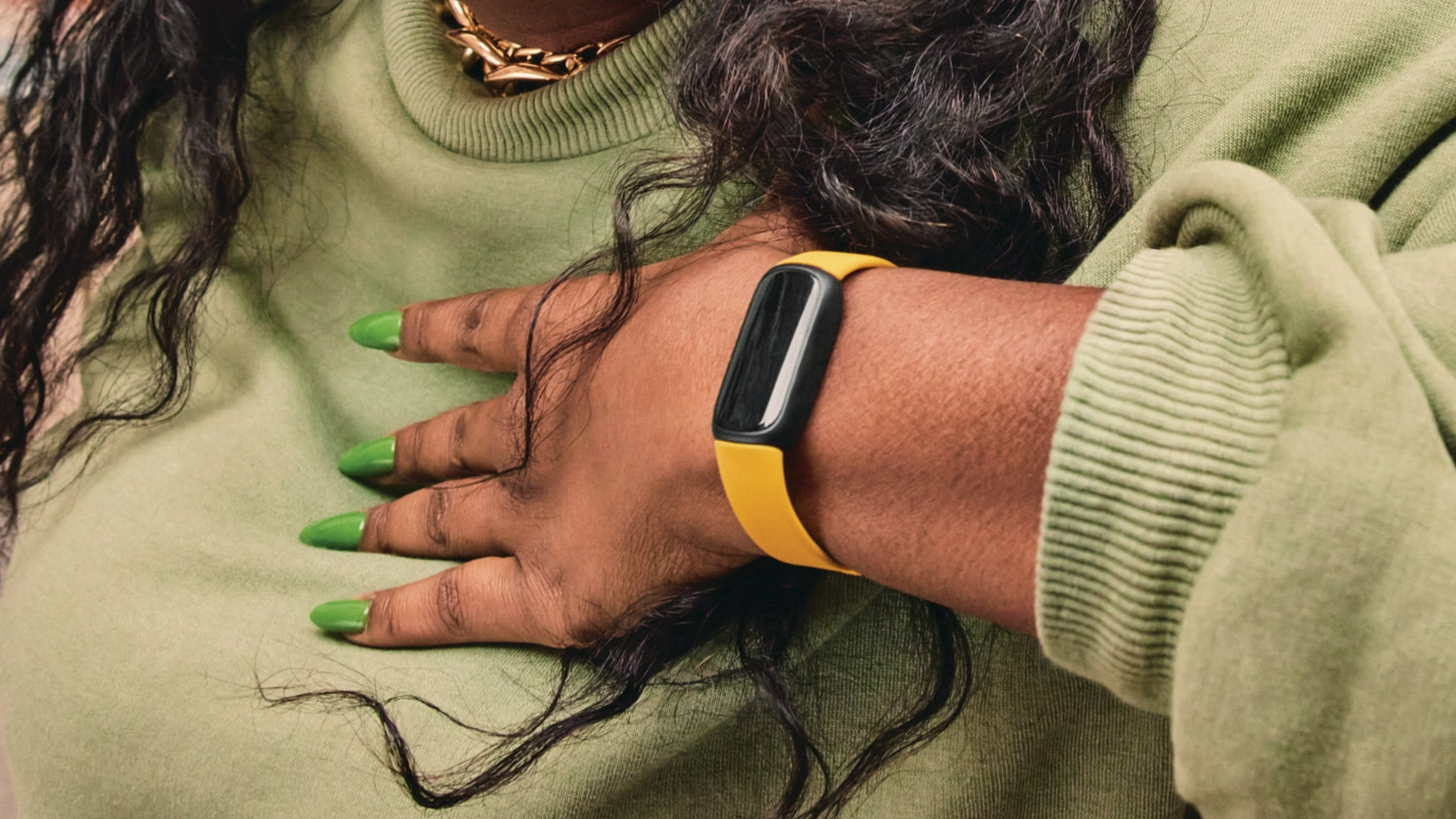 Um Fitbit Inspire 3 laranja no pulso de alguém.